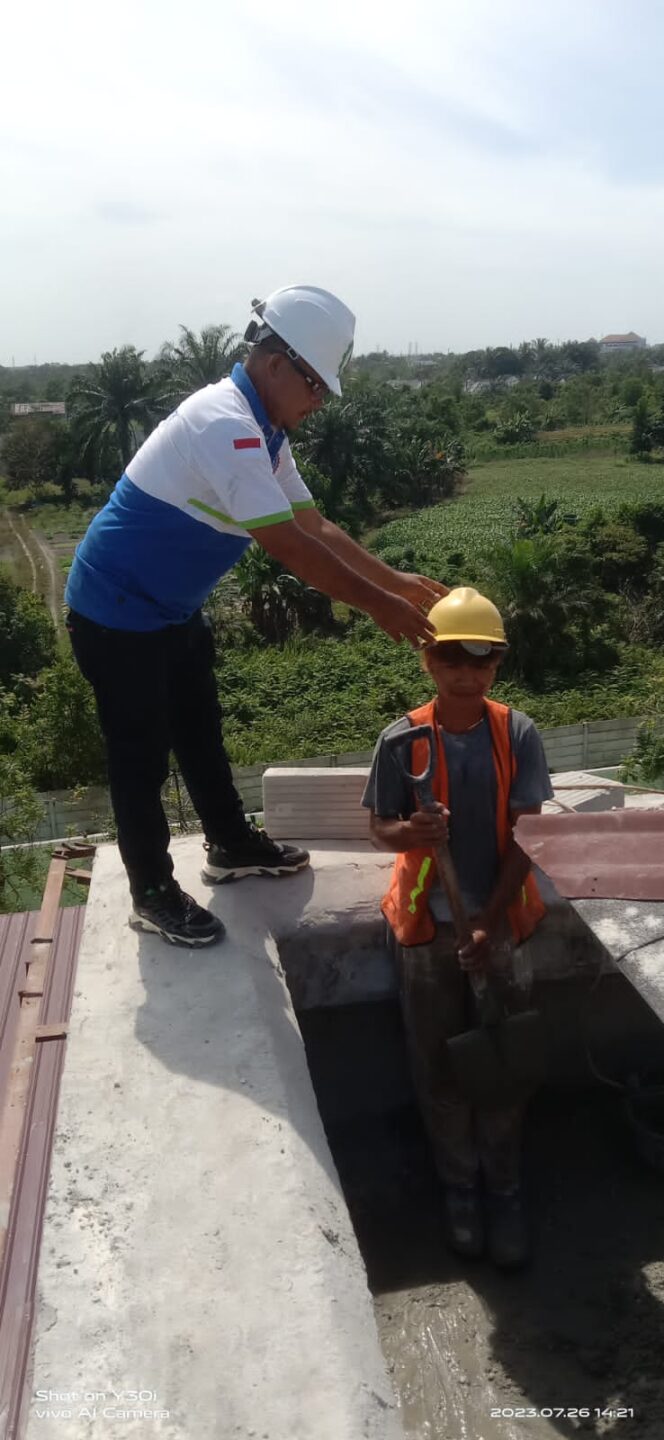 
 Ketua PD FSP Kerah Biru Riau memasangkan Helm kepada Tukang
